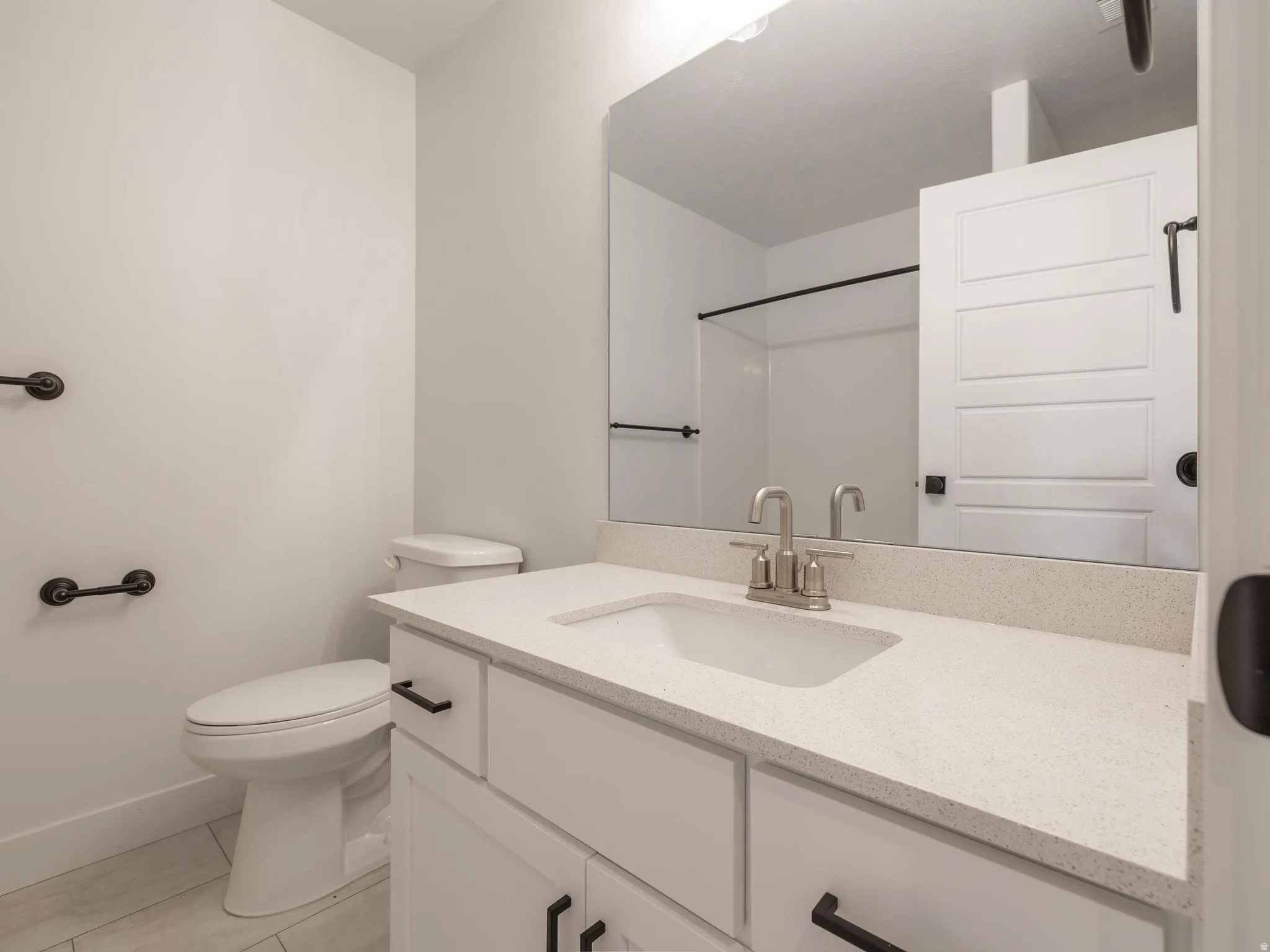 White vanity with a light-colored countertop, undermount sink, and brushed nickel faucet