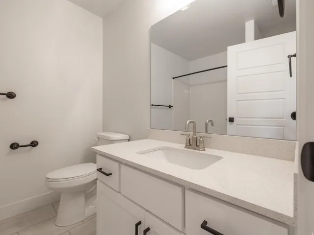 White vanity with a light-colored countertop, undermount sink, and brushed nickel faucet