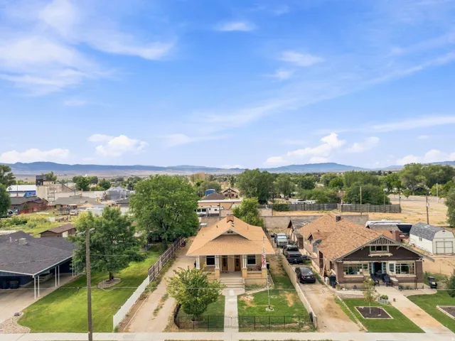 Aerial view showcasing this rural property featuring a distinctive dome-roofed residence with tan exterior, complemented by multiple outbuildings and structures across expansive grounds