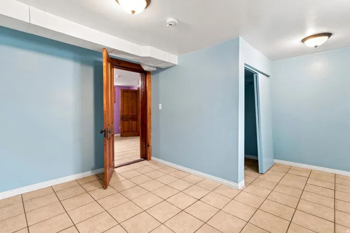 Tiled flooring, light blue wall paint, wood-finish interior doors, ceiling-mounted light fixtures, white trim