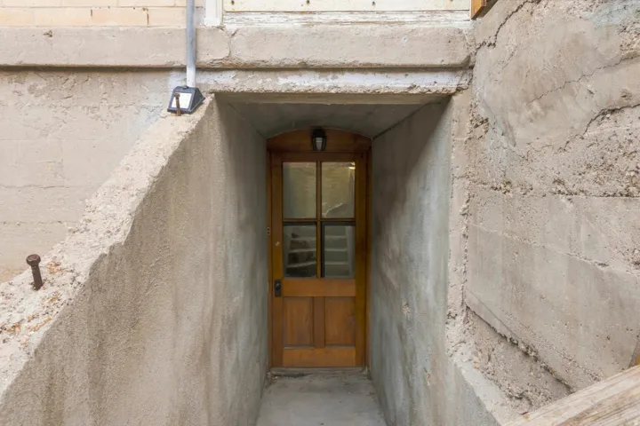 Wood-paneled door with glass inserts set within a concrete stairwell