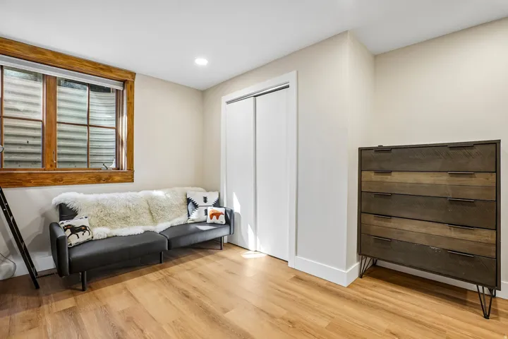 Wood-finish flooring with recessed lighting and a window featuring natural wood trim