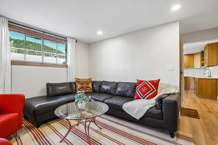 Recessed ceiling lighting, wood-finish flooring, white wall paint, and a multi-pane window