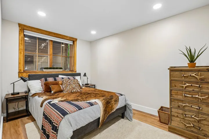 Recessed lighting, wood-finish flooring, and a large window with natural wood trim