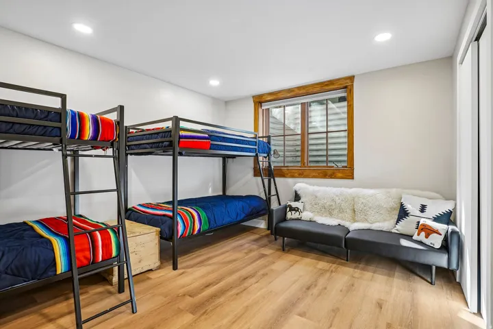 Recessed lighting, wood-finish flooring, and a natural wood-framed window