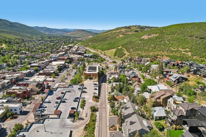 Central commercial district with diverse architecture, bordered by a residential area and lush green hillsides