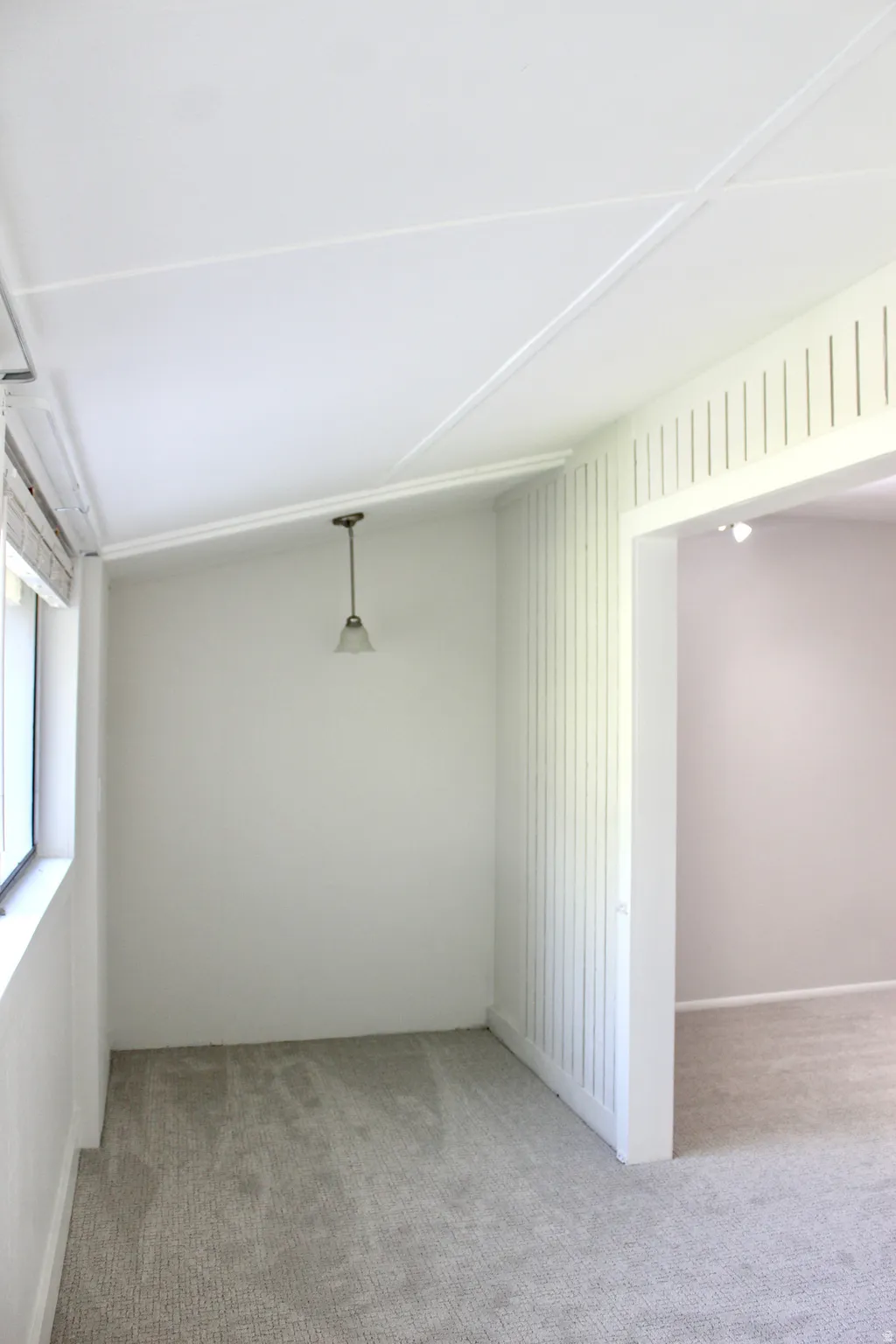 Recessed lighting, sloped ceiling, pendant light fixture, wall trim, grey carpeting
