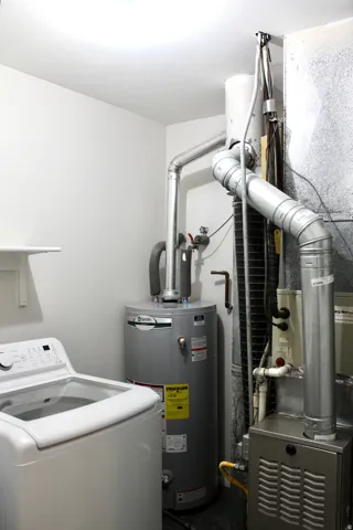 Dedicated utility space featuring a water heater, furnace, and laundry appliance