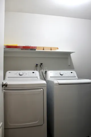 Laundry area featuring a top-load washing machine, front-load dryer, and a wall-mounted shelving unit