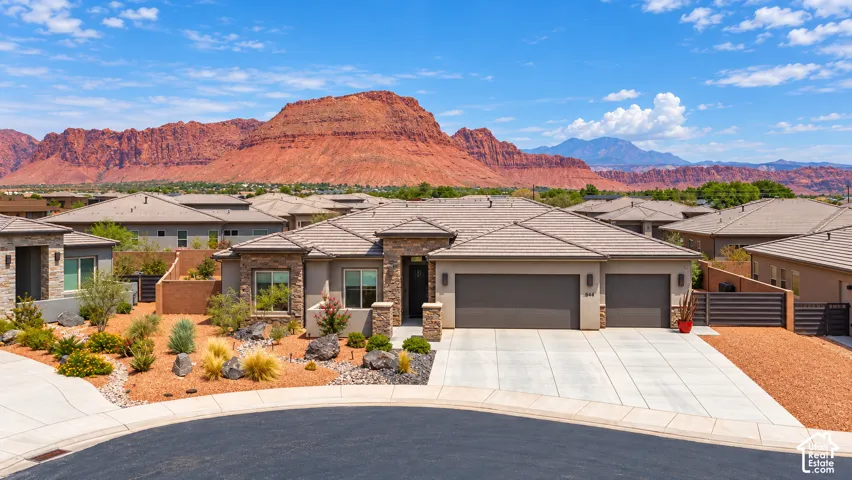 Single-story residence featuring a two-car garage and a stone and stucco facade