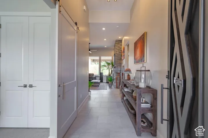 Hallway with recessed lighting, light-toned wall paint, and tile flooring