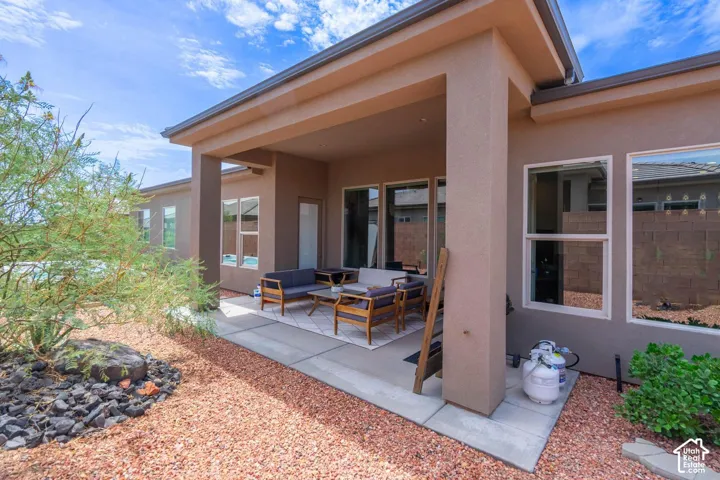 Covered patio with a concrete slab, surrounded by decorative rock landscaping