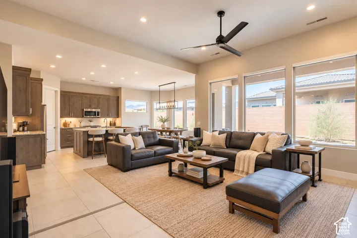 Open-concept living space featuring recessed lighting, a ceiling fan, and large windows