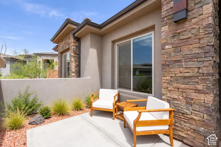 Modern patio retreat featuring a spacious concrete entertaining surface, stepped architectural detailing, and direct access to the home via large sliding glass doors