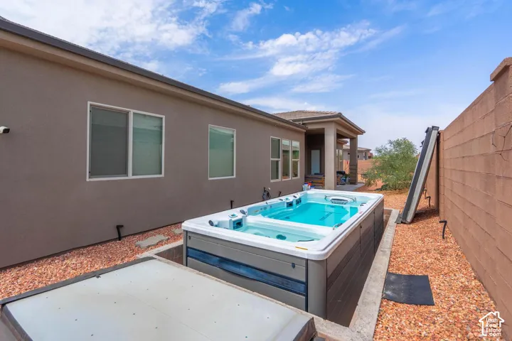 Contemporary exterior with a built-in spa, stucco finish, and gravel landscaping