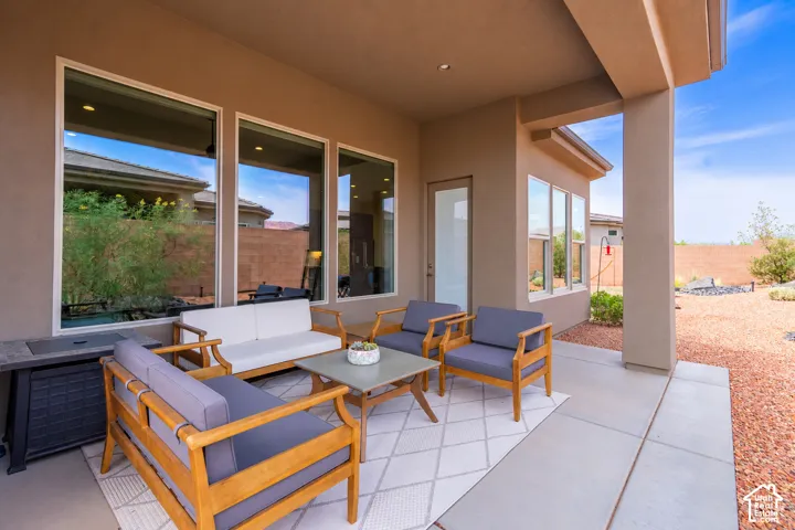 Covered patio with a concrete surface, large windows, and an exterior door