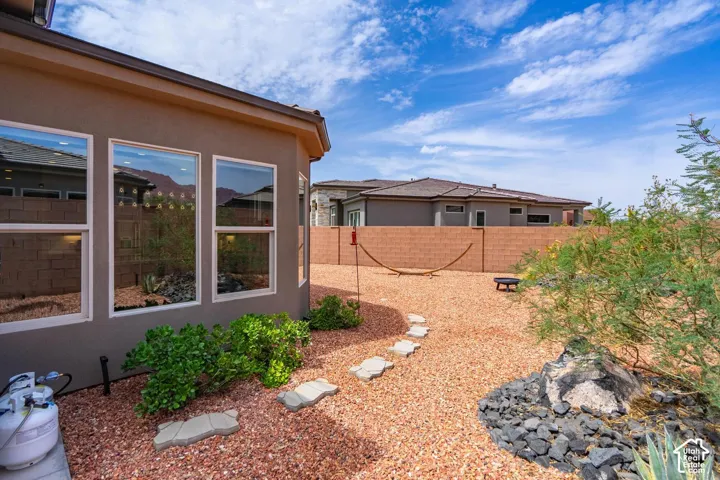 Hardscaped backyard featuring gravel ground cover, a concrete block privacy wall, and desert landscaping