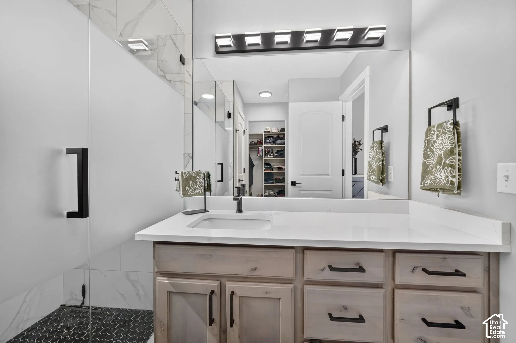Modern vanity with integrated sink, white countertop, and light wood-finish cabinetry