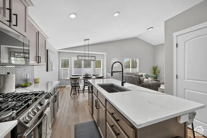 Kitchen with white countertops, a stainless steel gas range, and a herringbone tile backsplash