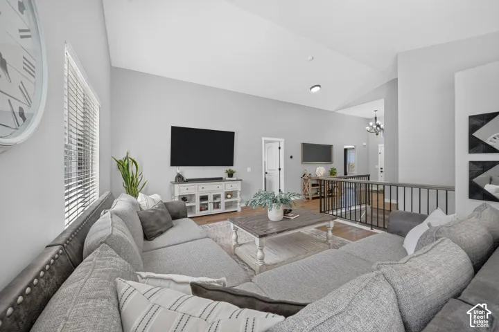 Vaulted ceilings, light gray wall finishes, recessed lighting, and wood-finish flooring