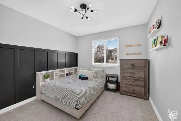Carpeted flooring, window with blinds, wall-mounted shelving, built-in wall paneling