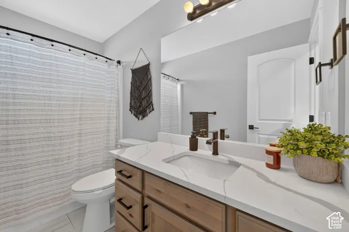 Wood-finish vanity with drawer storage, white countertop, integrated rectangular sink, and matte black faucet