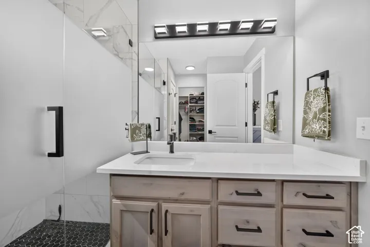 Modern vanity with integrated sink, white countertop, and light wood-finish cabinetry