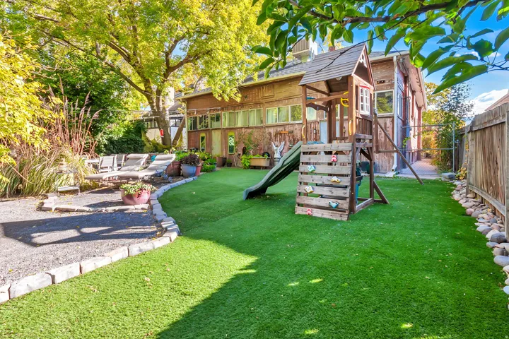 Expansive artificial turf lawn bordered by stone edging