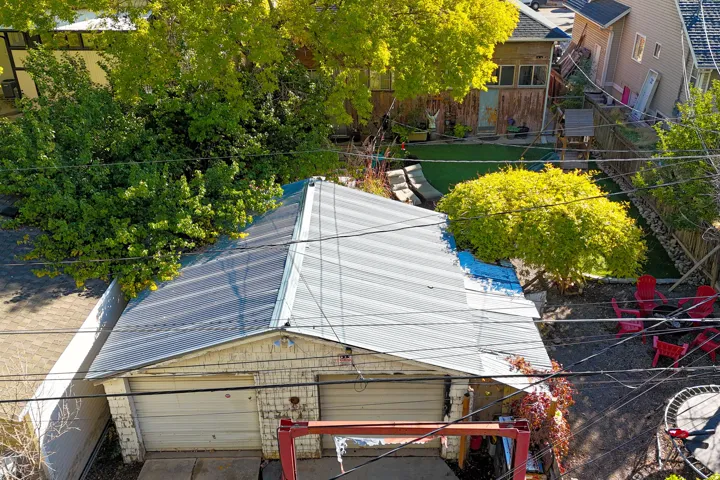 Two-car garage with white garage doors and a corrugated metal roof