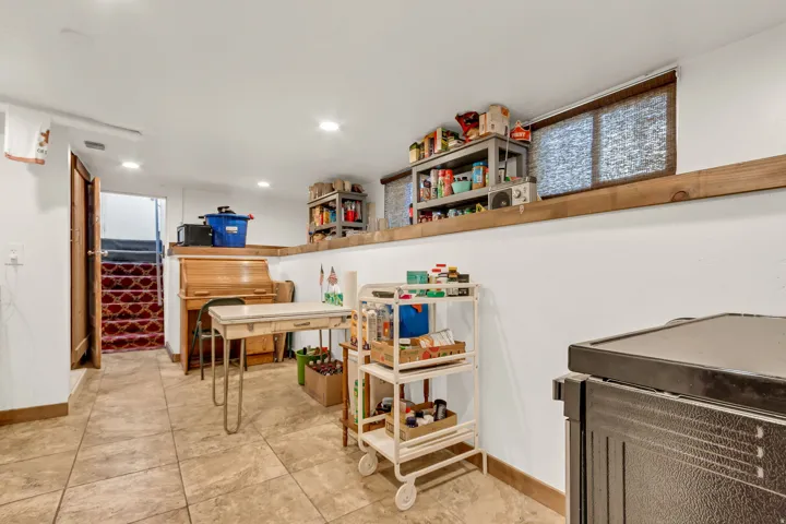 Recessed ceiling lighting, durable tile flooring, and a window with a woven shade