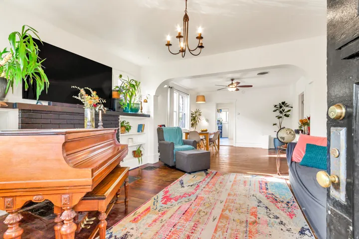Hardwood flooring, arched doorway, recessed shelving, ceiling fan, and chandelier