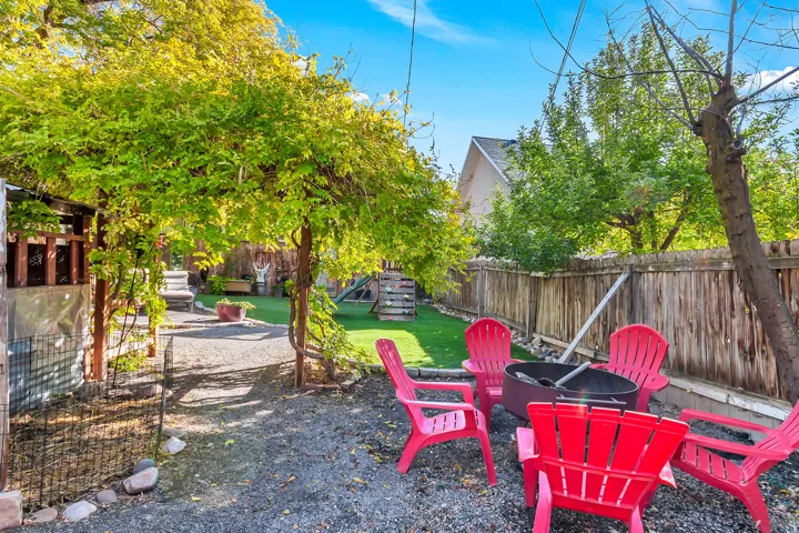 Gravel hardscaping area with a fire pit, bordered by a wooden fence