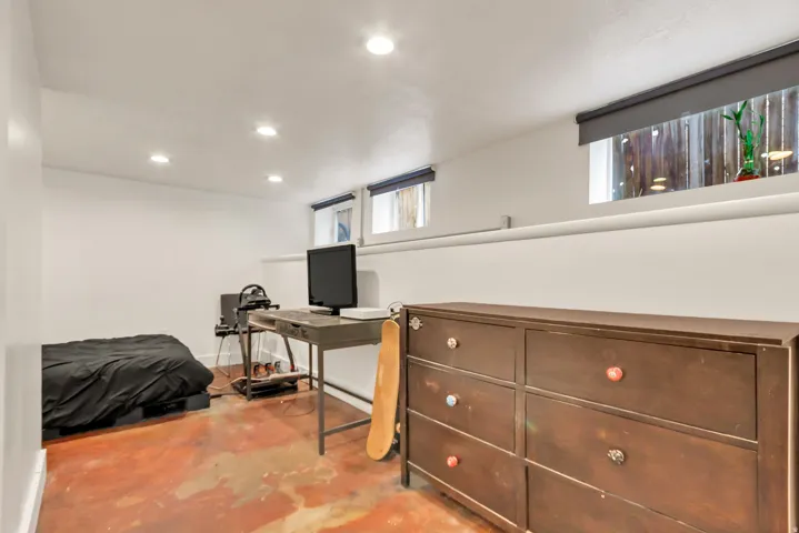 Recessed lighting, white walls, and two windows with roller shades