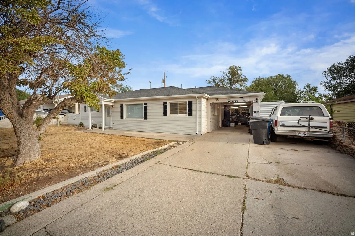 Single-story residence featuring siding exterior, an attached carport, and a concrete driveway