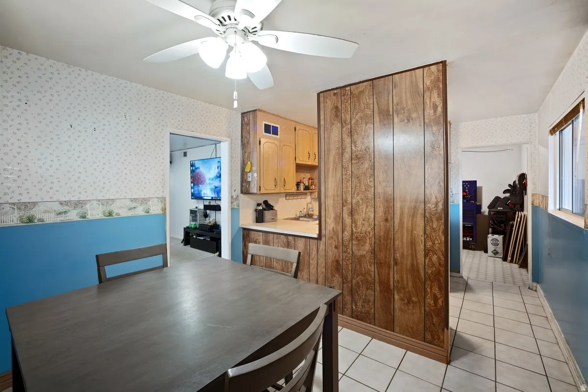 Kitchenette with wood-finish cabinetry, white countertop, and tiled flooring