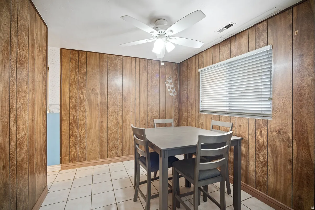 Wood-paneled walls with a window featuring horizontal blinds