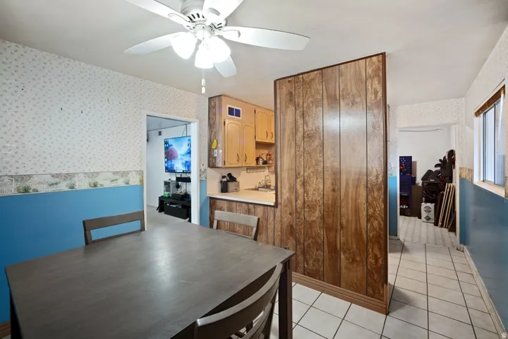 Kitchenette with wood-finish cabinetry, white countertop, and tiled flooring
