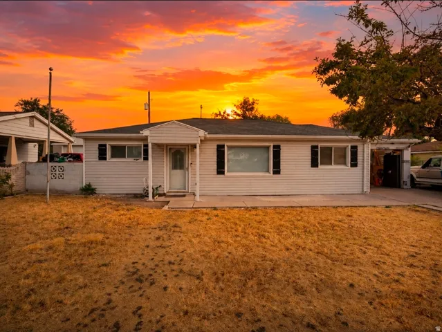 Ranch-style exterior with white siding, black shutters, and an attached carport