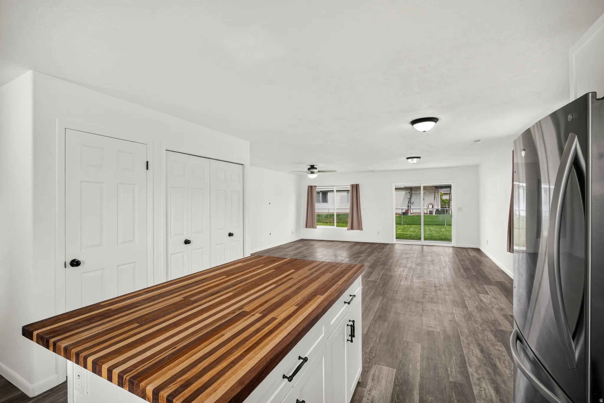 Wood-finish flooring, white walls, and a wood butcher block countertop
