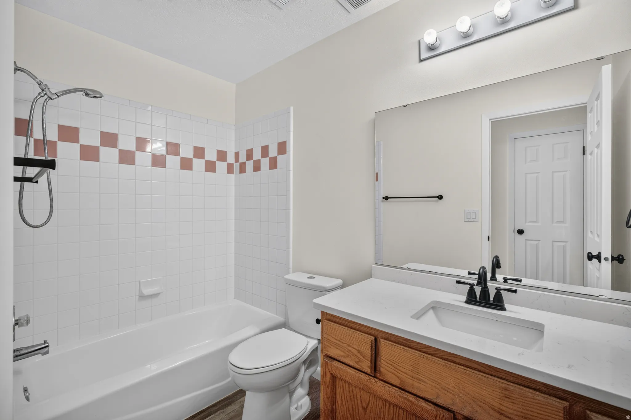 Vanity with a light-toned countertop, integrated rectangular sink, and matte black faucet