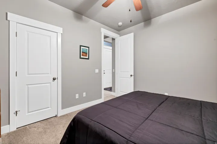 Plush carpet flooring, neutral paint palette, white trim, solid core doors with brushed nickel hardware, and a ceiling fan