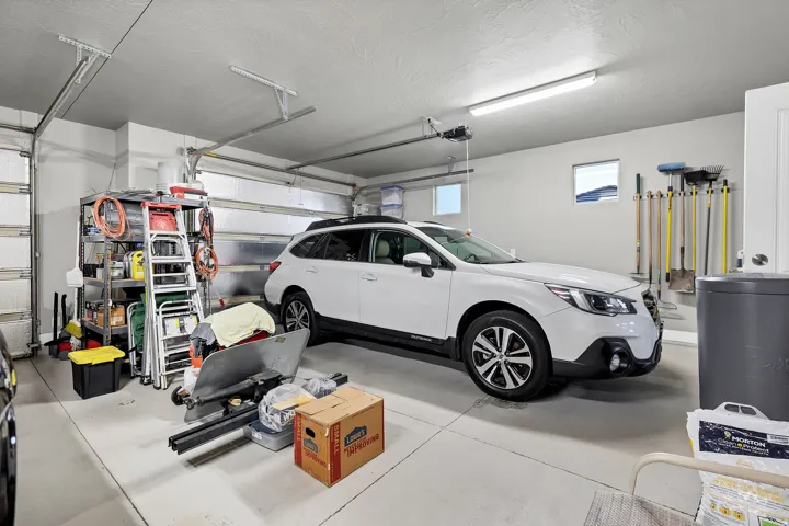 Attached garage with a concrete floor, two windows, and overhead lighting