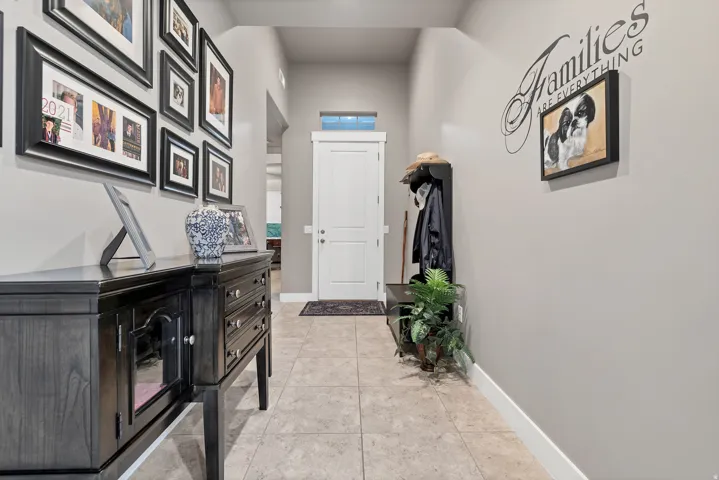 Hallway with tile flooring, neutral wall paint, and white trim