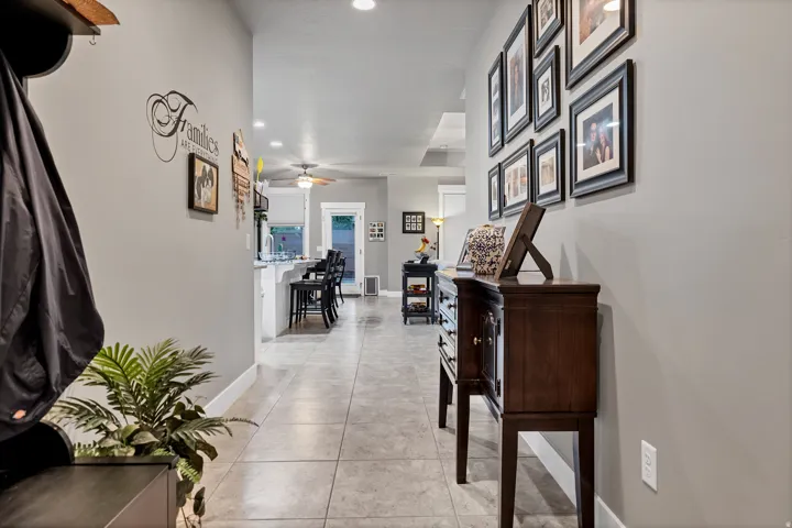 Hallway with tile flooring, light gray wall finishes, and recessed lighting