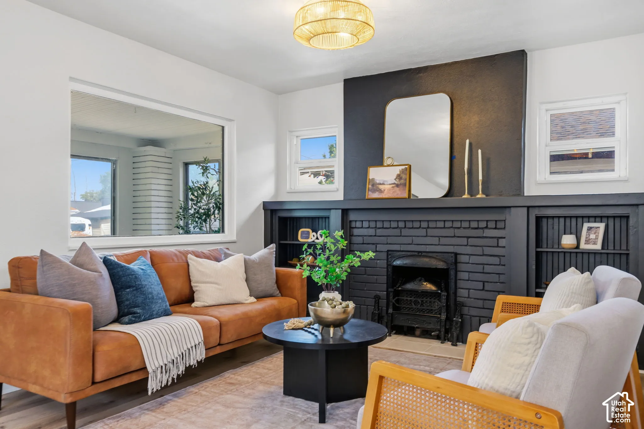 Built-in fireplace with brick surround, built-in shelving, large wall niche, and warm wood-finish flooring