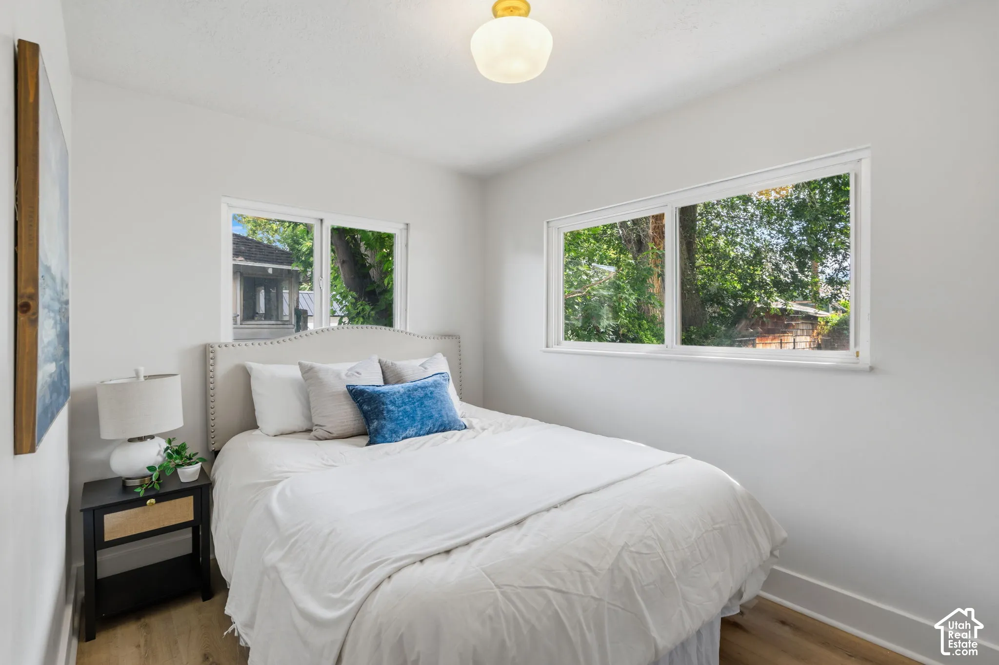 Wood-finish flooring, white walls, and a single light fixture
