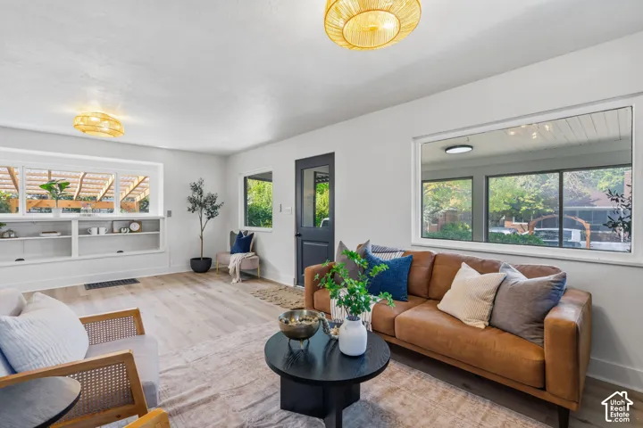 Recessed built-in shelving, wood-finish flooring, multiple windows, and decorative ceiling light fixtures