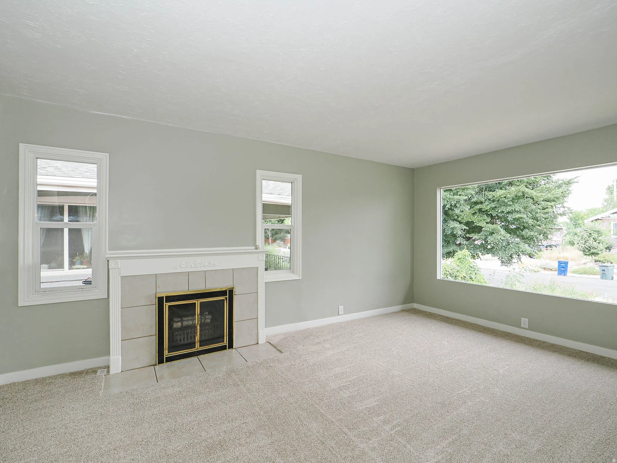 Living room featuring a wood-burning fireplace framed by windows