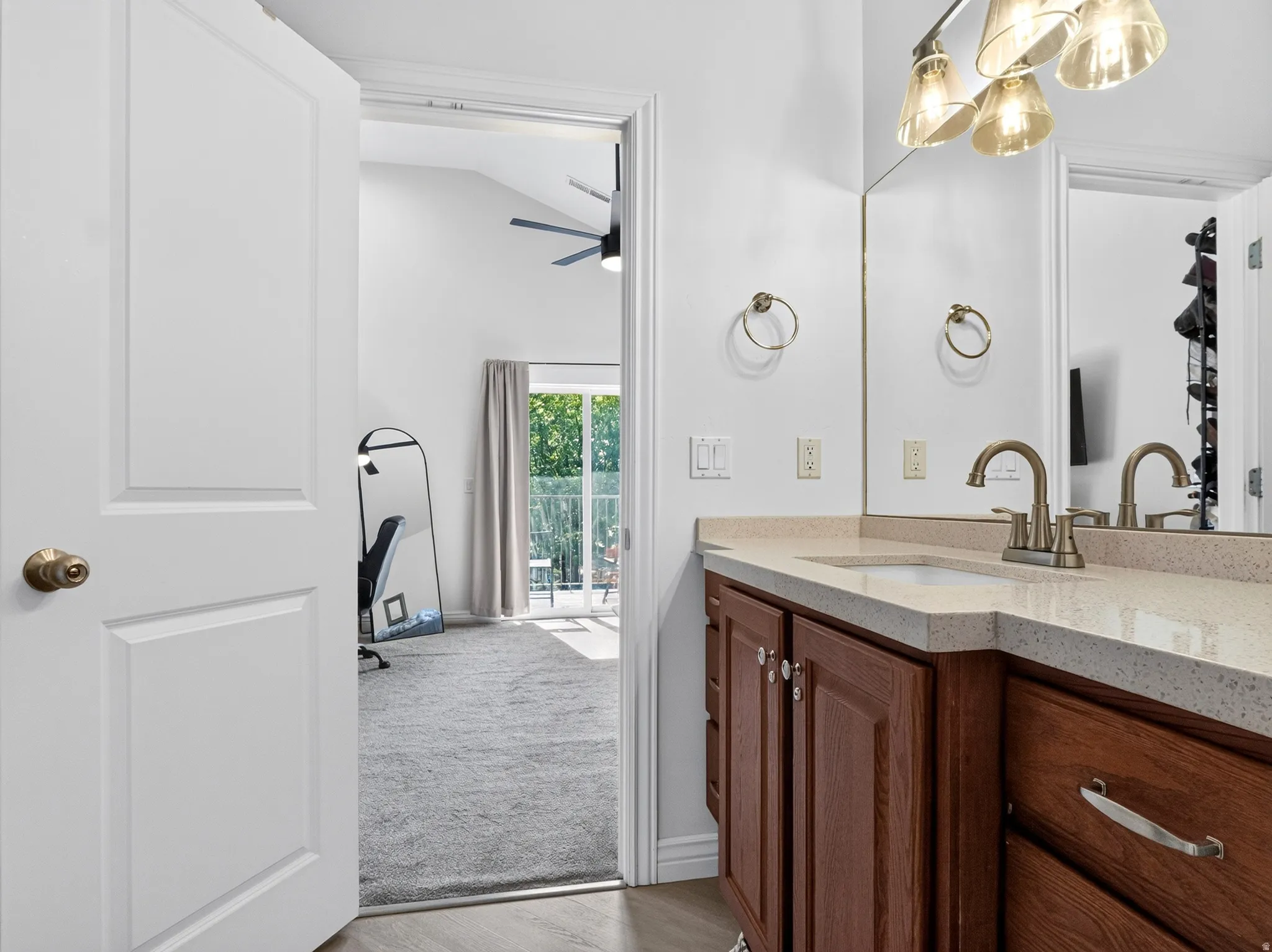 Spa-inspired primary bathroom featuring a wood-finish vanity with dual sinks, quartz countertop, and brushed nickel faucetry