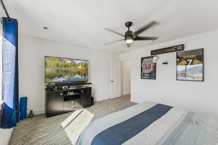 White walls with a ceiling fan, patterned carpet, and a white paneled door